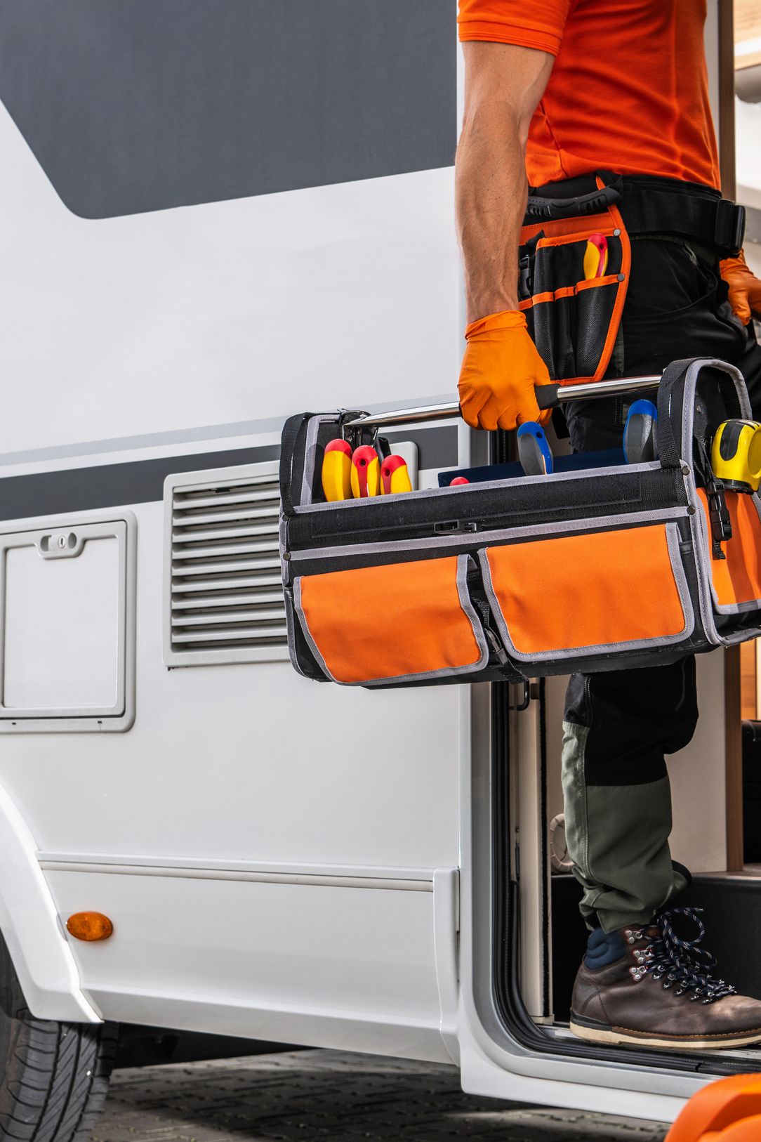 Man walking into RV with tools